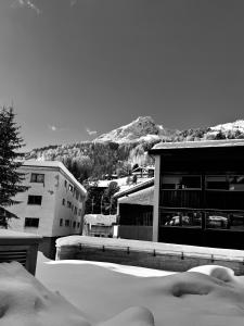 a black and white photo of a building with snow at Design Flat Hidden Pearl Davos in Davos