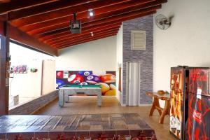 een woonkamer met een bank en een tafel bij Rubi casa de temporada com piscina aquecida e área gourmet in Santa Fé do Sul