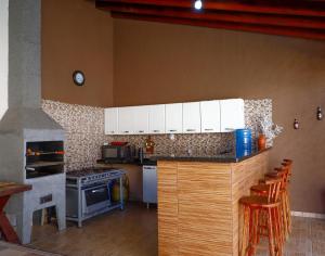 een keuken met witte kasten en een fornuis met oven bij Rubi casa de temporada com piscina aquecida e área gourmet in Santa Fé do Sul