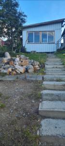 a pile of logs in front of a house at Cabaña Puerto Williams in Puerto Williams