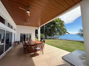 eine Terrasse mit einem Tisch, Stühlen und Meerblick in der Unterkunft Sand Castle Villa - Classic Beachfont Luxury 