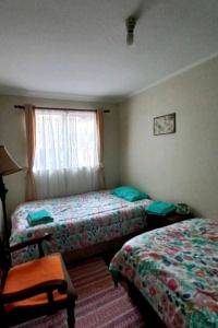a hotel room with two beds and a window at Casa con buena ubicación estacionamiento gratuito in Castro
