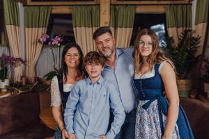 a family posing for a picture in a living room at Hotel Forsthof in Sankt Johann im Pongau