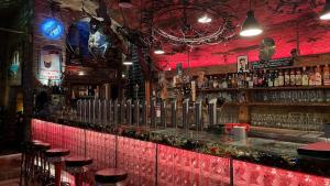 a bar with stools and a red wall at Alfred First in Regensburg