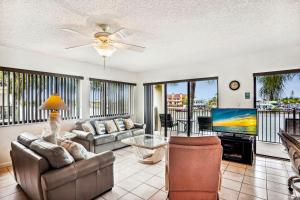 ein Wohnzimmer mit einem Sofa und einem TV in der Unterkunft Land's End 4-201 Bay Front in St Pete Beach