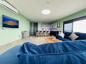 a living room with a blue couch and a table at Aquarius Kigo Resort in Kigo