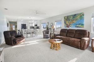 a living room with two couches and a table at Sea Breeze 401 in St Pete Beach