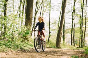 uma mulher a andar de bicicleta num trilho na floresta em Villa Oliva em Sanlúcar la Mayor