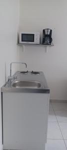 a kitchen counter with a sink and a microwave at Nature & Zénitude - Morne-à-l'Eau 