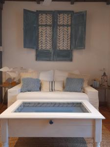 ein Wohnzimmer mit einem weißen Sofa und einem Tisch in der Unterkunft Villa Oliva in Sanlúcar la Mayor