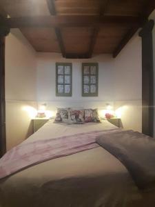 um quarto com uma cama grande e 2 janelas em Villa Oliva em Sanlúcar la Mayor