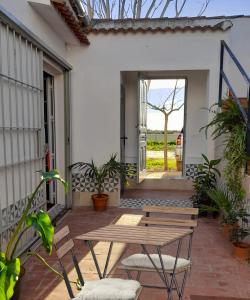 eine Terrasse mit einem Holztisch und Stühlen in der Unterkunft Villa Oliva in Sanlúcar la Mayor