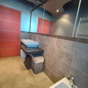 a bathroom with a sink and a red door at B&B Casa Lilla in Verzuolo +34 photos