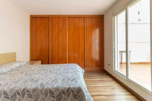 a bedroom with a bed and a large window at Precioso piso in Catarroja