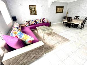een woonkamer met een paarse bank en een tafel bij Appartement centre-ville avec Wifi Fibre Optique in Fès