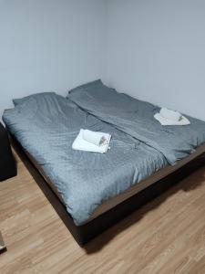 a bed with two towels on top of it at Apartmani Hub in Niš