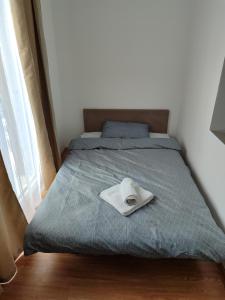 Apartmani Hub في نيشْ: سرير عليه قبعة بيضاء