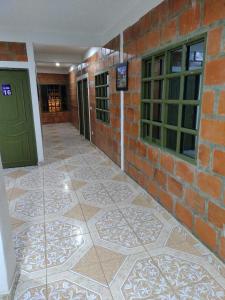 a brick building with a green door and a tile floor at Hospedaje la Viña in El Cerrito