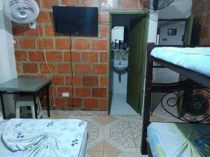 - une chambre avec un mur en briques et une chambre avec des lits superposés dans l'établissement Hospedaje la Viña, à El Cerrito
