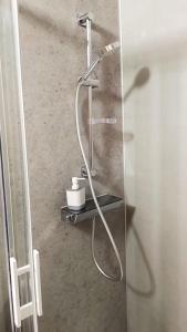 a shower with a hose in a bathroom at The Silent T1 city center JO 2024 PARIS in Chevreuse