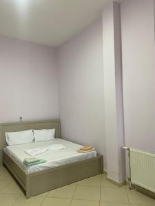 a bed in a room with a white wall at Hotel Tani in Ulëz +8 photos