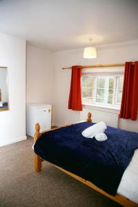 um quarto com uma grande cama azul e uma janela em Colney Lane Lodge em Colney