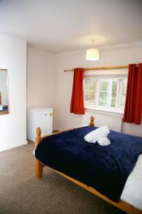 a bedroom with a large blue bed with a window at Colney Lane Lodge in Colney