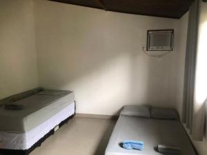 Duas camas num pequeno quarto com uma televisão em Casa Cachoeira Paraty em Paraty