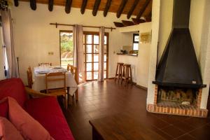 a living room with a fireplace and a dining table at Bellamar Apart Hotel in Bella Vista