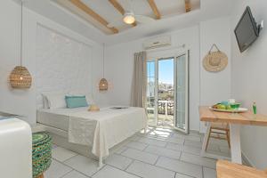 a white bedroom with a bed and a balcony at Sofi pension in Naxos Chora
