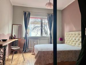 a bedroom with a bed and a desk and a window at Eternity Apartment: Award-Winning Design in the Heart of the City Center in Sofia