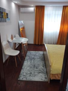 ein Wohnzimmer mit einem Tisch, einem Sofa und einem Teppich in der Unterkunft Sunshine apartment near the zoo, free parking in Sarajevo