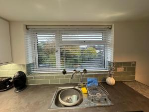 a kitchen counter with a sink and a window at modern 1 bed apartment with car parking in Bitton