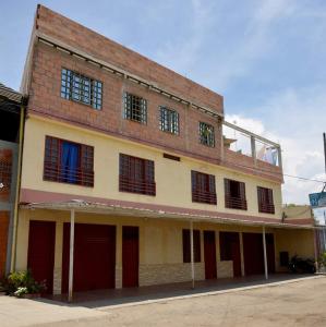 - un bâtiment en briques avec des portes et des fenêtres rouges dans l'établissement Hospedaje la Viña, à El Cerrito
