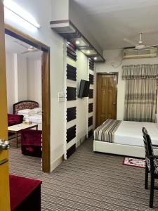 um quarto de hotel com uma cama e uma televisão em city Homes em Daca