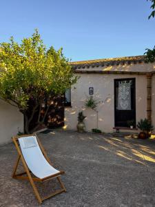 una silla sentada frente a una casa en Baglio Anastè, en Buseto Palizzolo