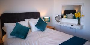 a bedroom with a bed with blue pillows and a mirror at Classy yet cosy and close to Chester City Centre in Chester