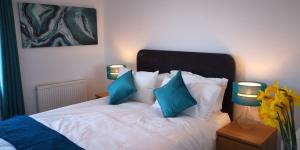Classy yet cosy and close to Chester City Centre في تشيستر: غرفة نوم مع سرير ووسائد زرقاء
