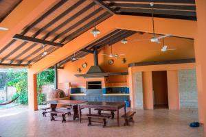 een open keuken met een houten tafel en banken bij Quinta Los Lapachos de Ypané in Ypane