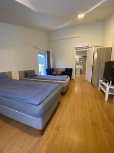 Habitación grande con 2 camas y suelo de madera. en Perlos Apartamentai 9, en Birštonas