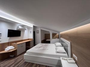 um quarto de hotel com uma cama e uma televisão em Hotel Colis em Tirana