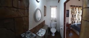 ein Badezimmer mit Waschbecken, Toilette und Spiegel in der Unterkunft Kiburi Cottage @ Kruger in Marloth Park + 47 Fotos