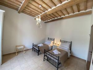 uma sala de estar com duas camas e uma mesa em B&B I Giardini em Pieve Torina