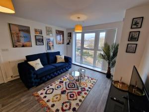 uma sala de estar com um sofá azul e um tapete em Ideal for Families & Businesses em Birmingham