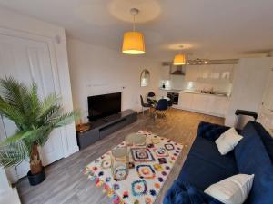 uma sala de estar com um sofá azul e uma mesa em Ideal for Families & Businesses em Birmingham