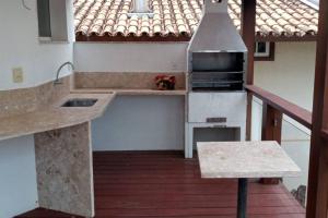 a kitchen with a counter top and a stove at Casa do Deck Inesquecível - Escarpas do Lago in Capitólio