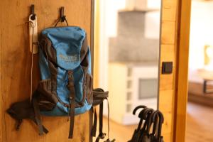 Ein blauer Rucksack hängt an der Wand in der Unterkunft Regitnig - 4 Sterne Hotel und Chalets in Weissensee