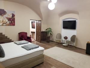 a bedroom with a bed and a tv and chairs at IMPERIAL ROOMS - ULTRACENTRAL - jacuzzi cu hidromasaj in Oradea