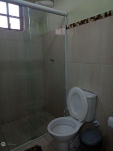 ein Bad mit einem WC und einer Glasdusche in der Unterkunft Casa familiar in Paraty