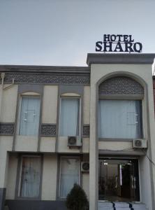 een hotel sharma gebouw met een bord erop bij Sharq hotel in Urganch